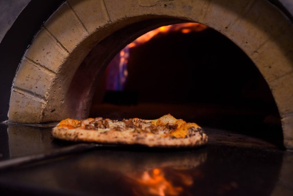 pizza leaves the oven at brick + dough