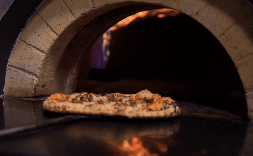 Pizza leaving the oven at Brick + Dough