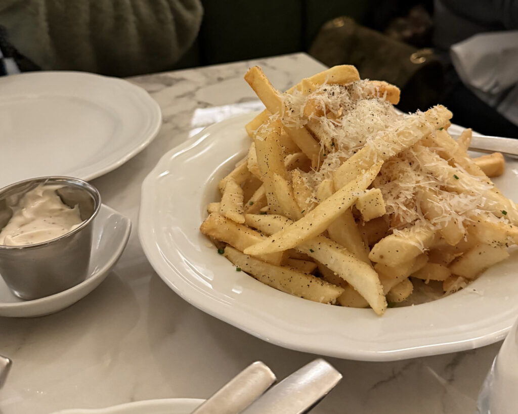 cacio e pepe fries adorned with black pepper and shaved parmigiano