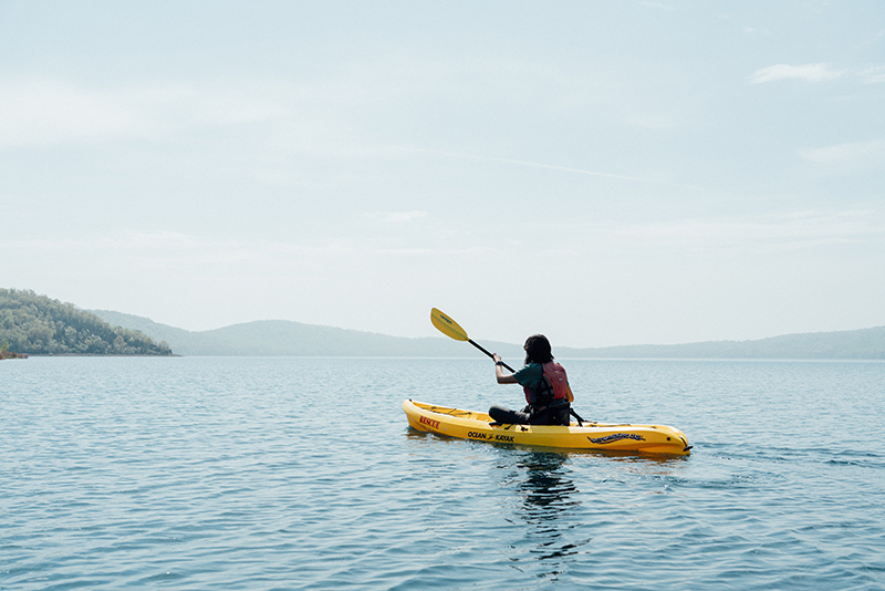 A kayaker paddling on Round Valley Reservoir in Clinton, New Jersey on a summer day