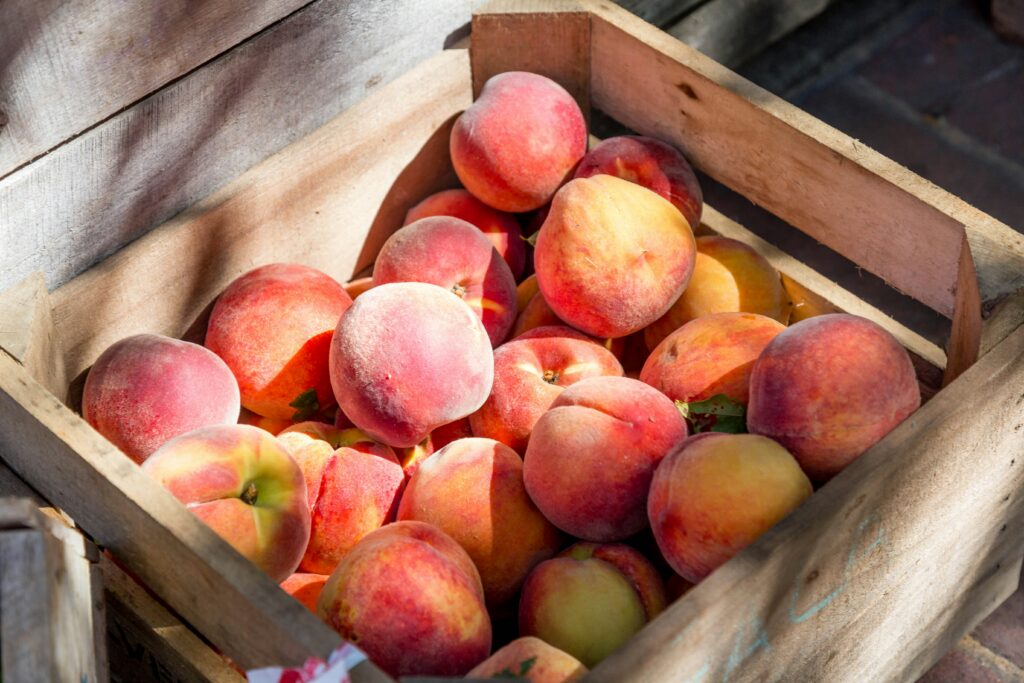 A wooden crate filled with fresh peaches at a North Jersey farm