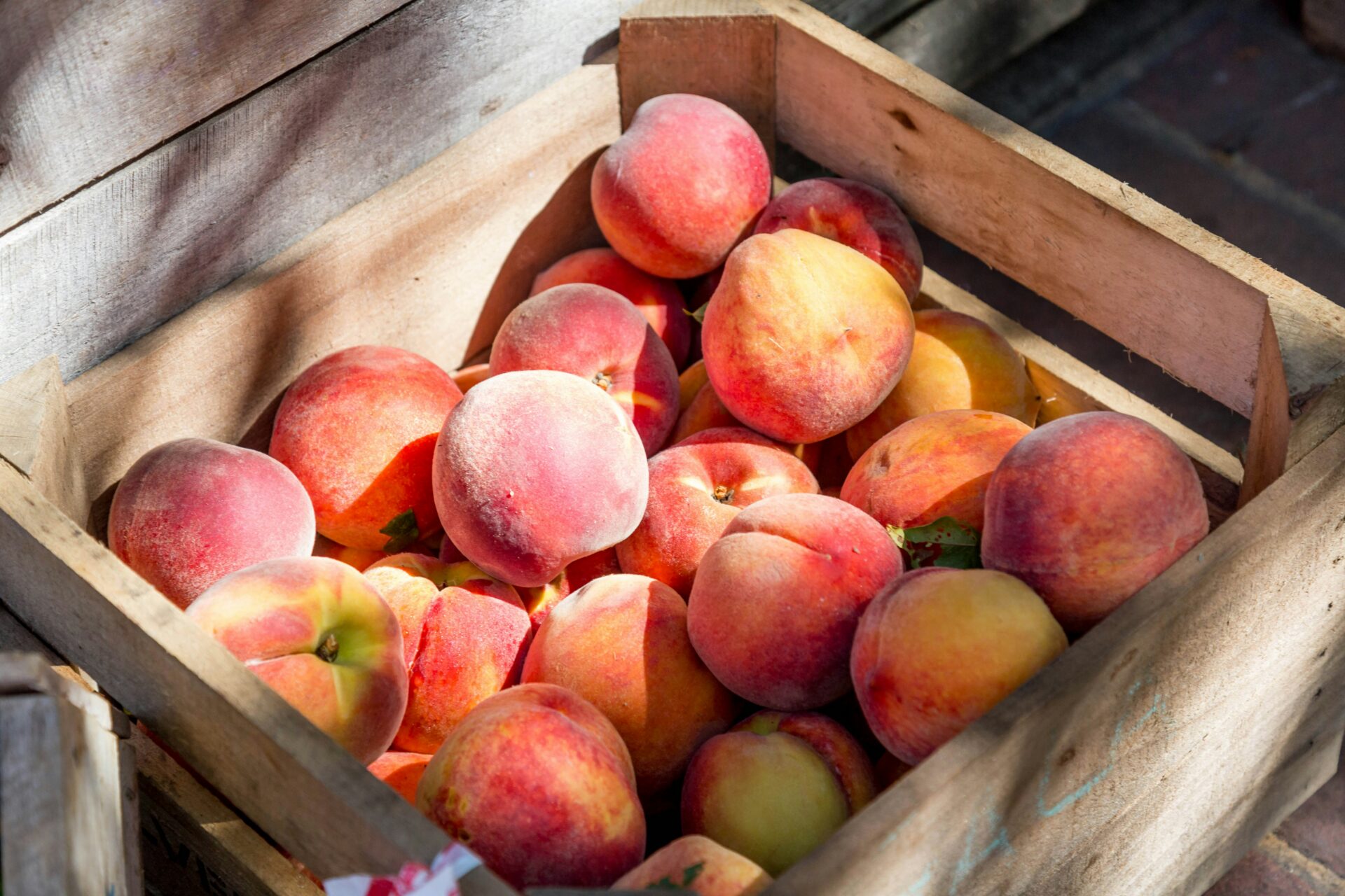 A wooden crate filled with fresh peaches at a North Jersey farm
