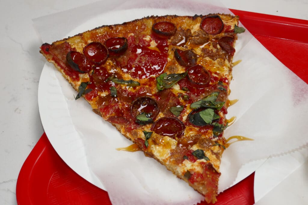 Hot honey, pepperoni and sausage top this slice
