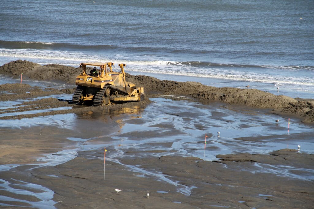 Dredging equipment pumps new sand onto a beach during a replenishment project.