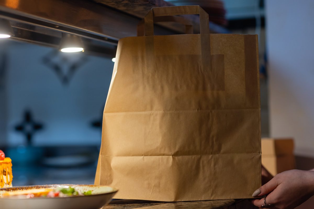 Takeout bag on a kitchen counter without plastic utensils