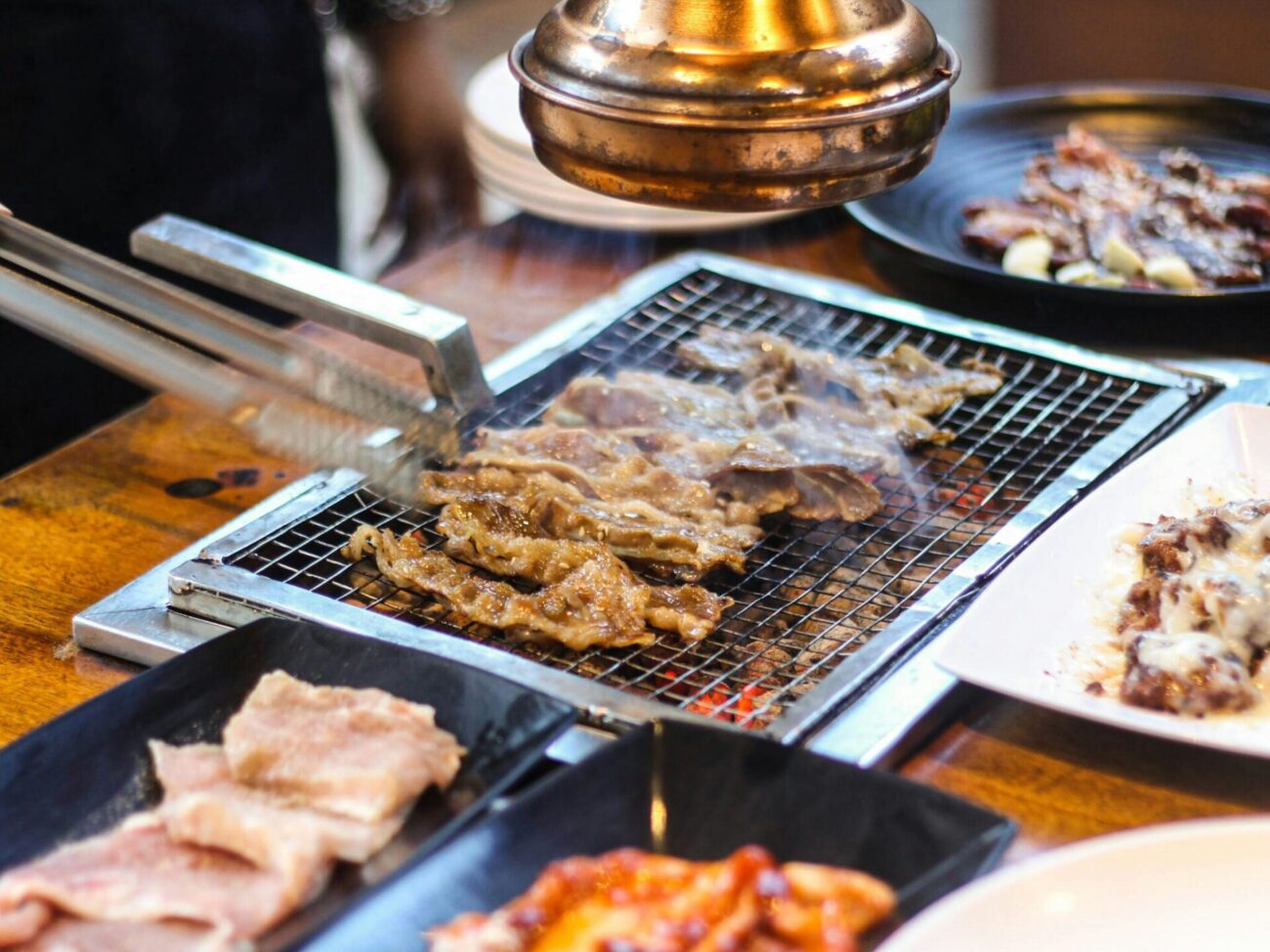 Grilled Korean BBQ meats cooking on a tableside grill at a New Jersey restaurant