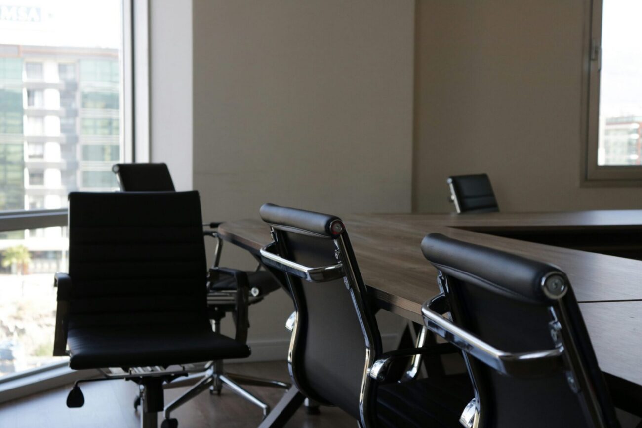 Empty office chairs in front of desks representing layoffs and workforce reductions