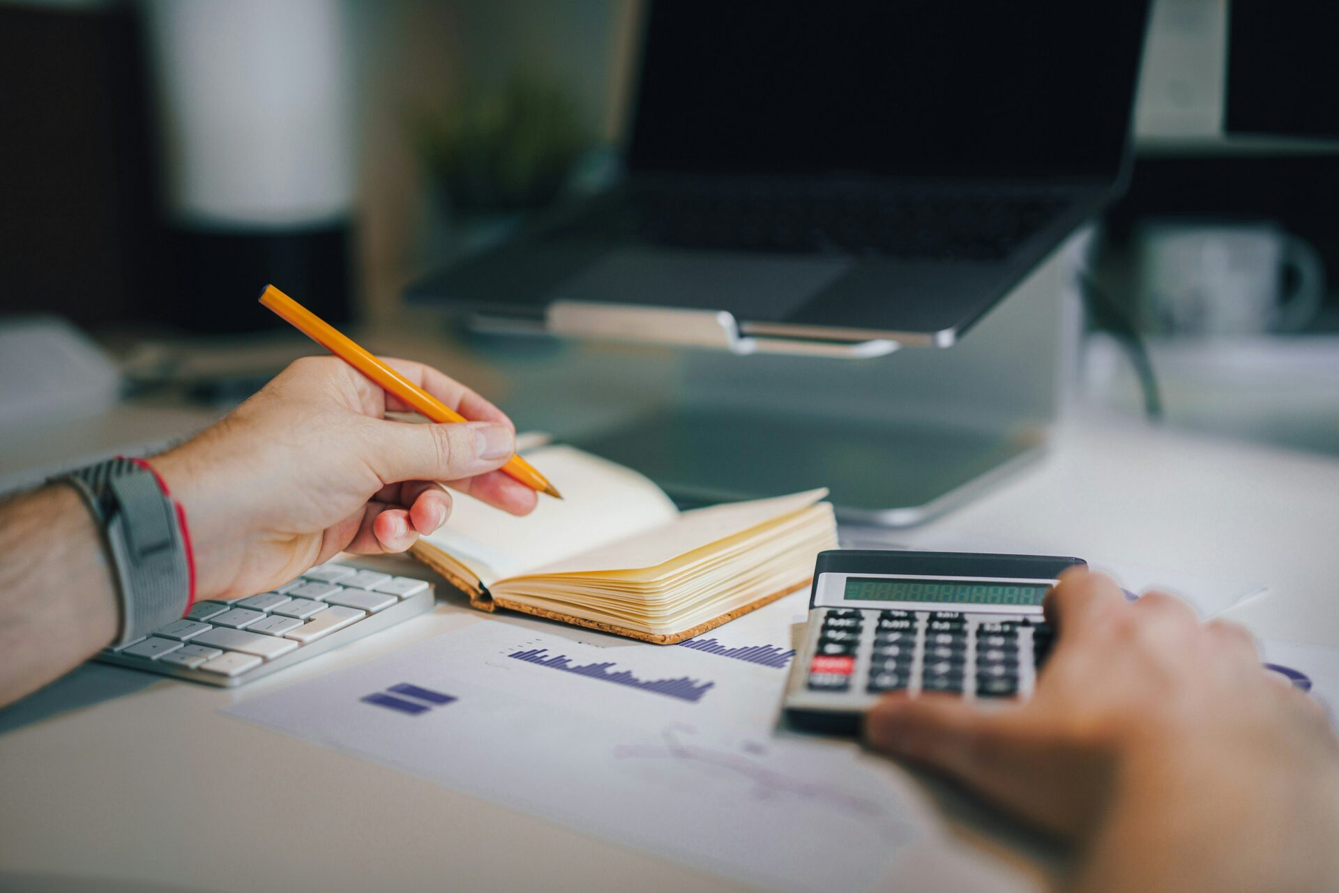 someone doing taxes with calculator and pencil