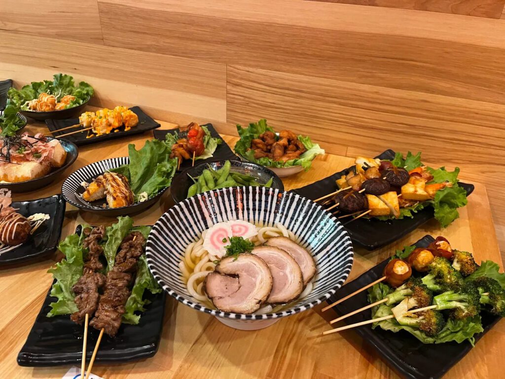 Udon noodle soup surrounded by other Japanese dishes at Umai Ramen in Cherry Hill