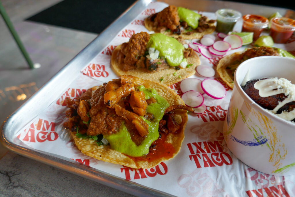 al pastor at ixim taco with pollo, carne asada and nopal behind it