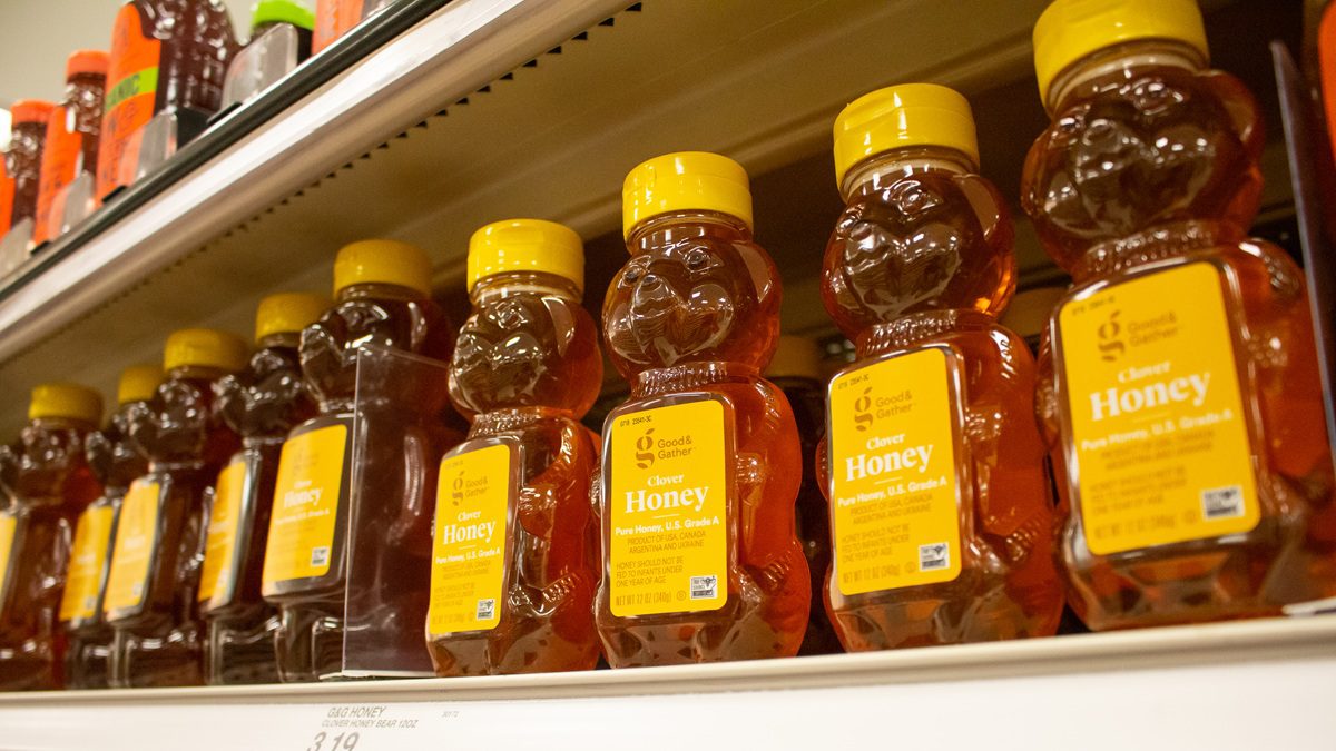 Bear-shaped honey bottles on a grocery store shelf where some products labeled “pure honey” may contain undeclared sweeteners.
