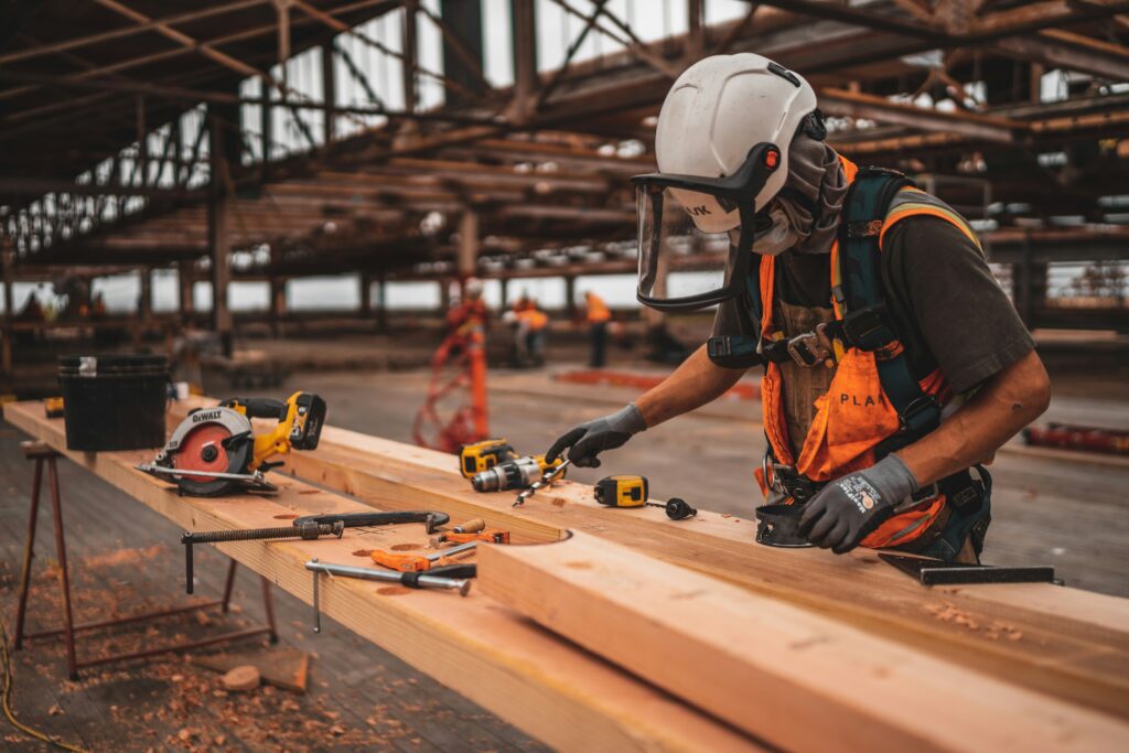 Young apprentice in safety gear using power tools while learning skilled trade through New Jersey's Earn and Learn Program
