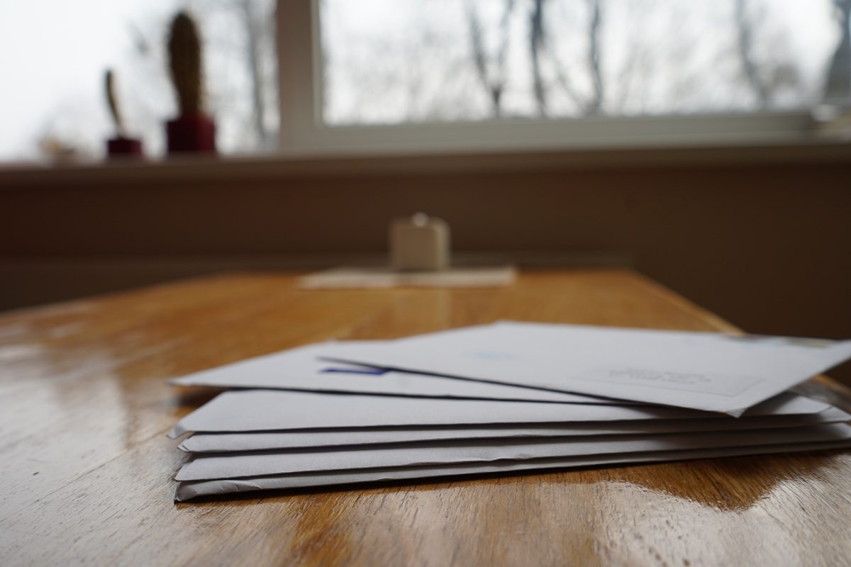 Stack of household mail and property tax bills on a kitchen table