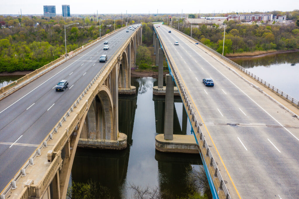 Drone view of Donald Goodkind Bridge spanning Raritan River in New Jersey, representing state infrastructure that ranks #50 nationally despite high taxpayer taxes
