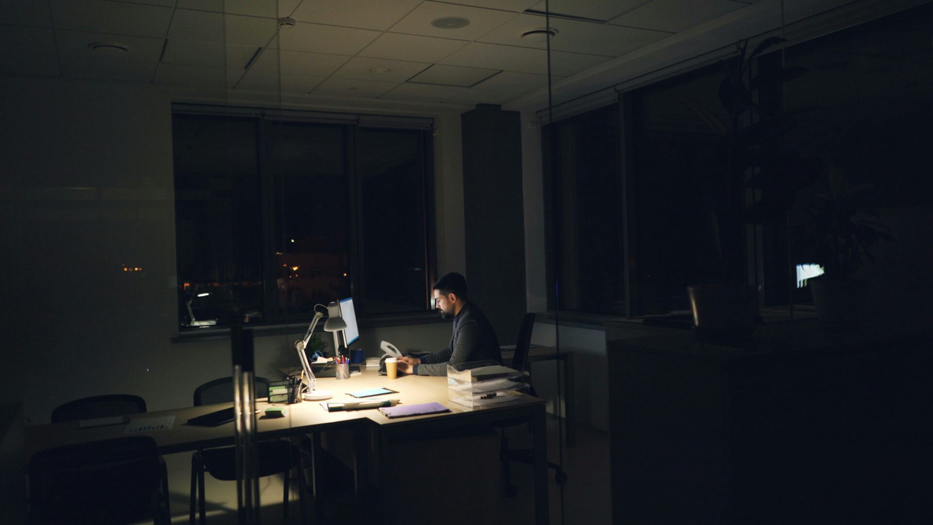 Tired worker late at night grinding through extra hours to afford basic cost of living in New Jersey