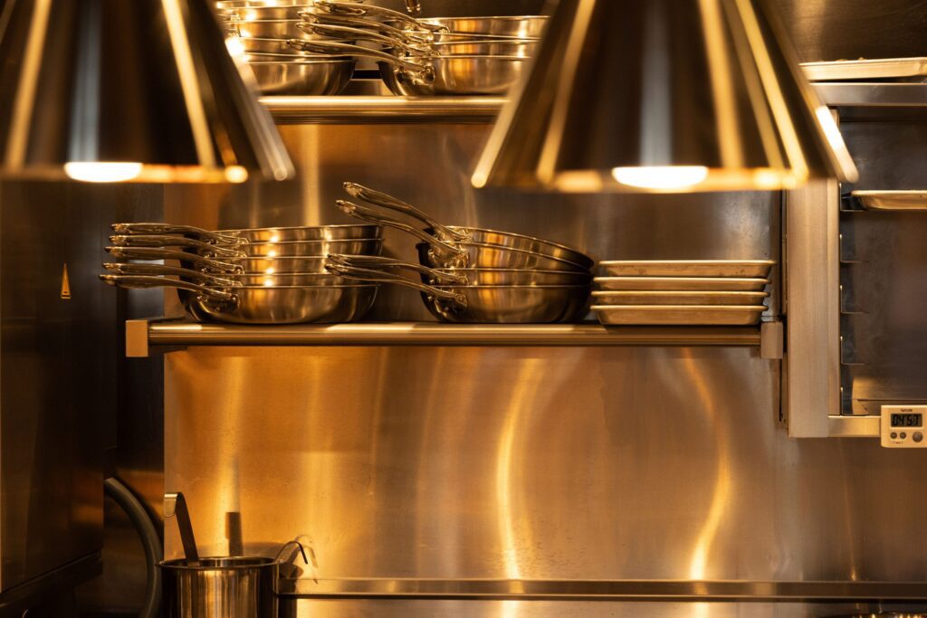 Adelaide's kitchen with stacked pans and stainless steel