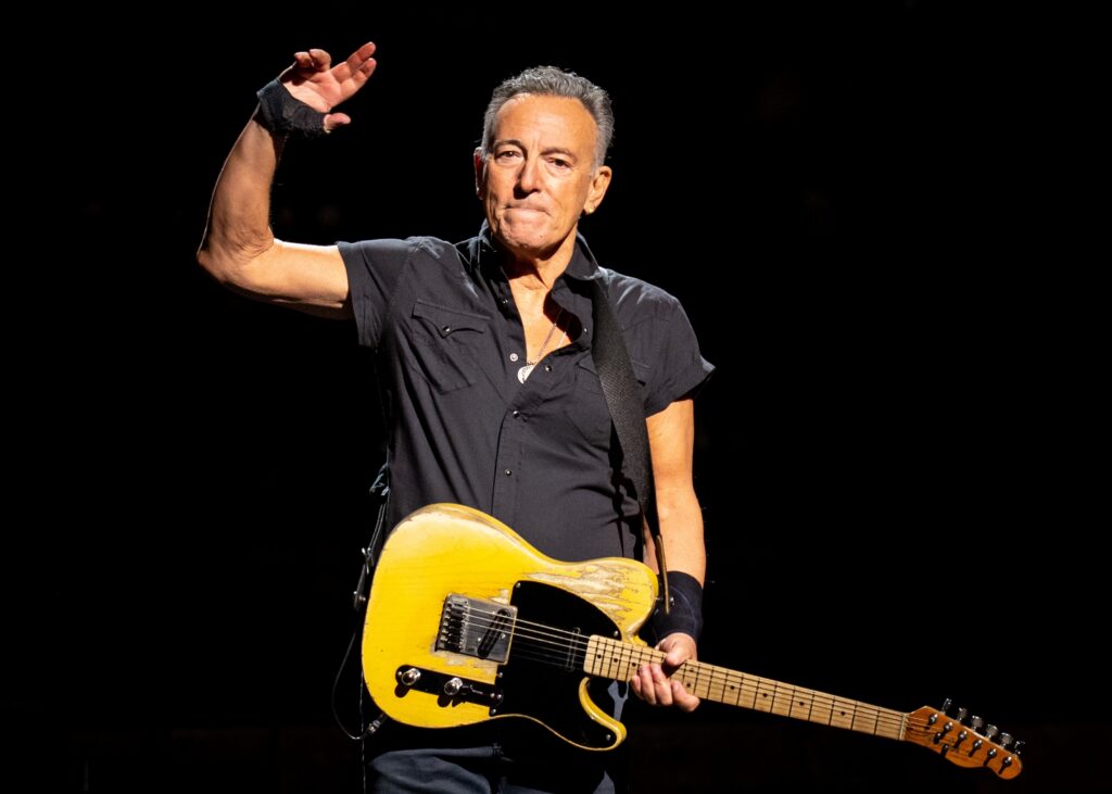 Bruce Springsteen performing on stage with his guitar