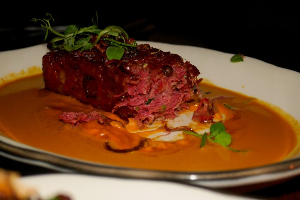 crispy pressed oxtail over vibrant orange curry