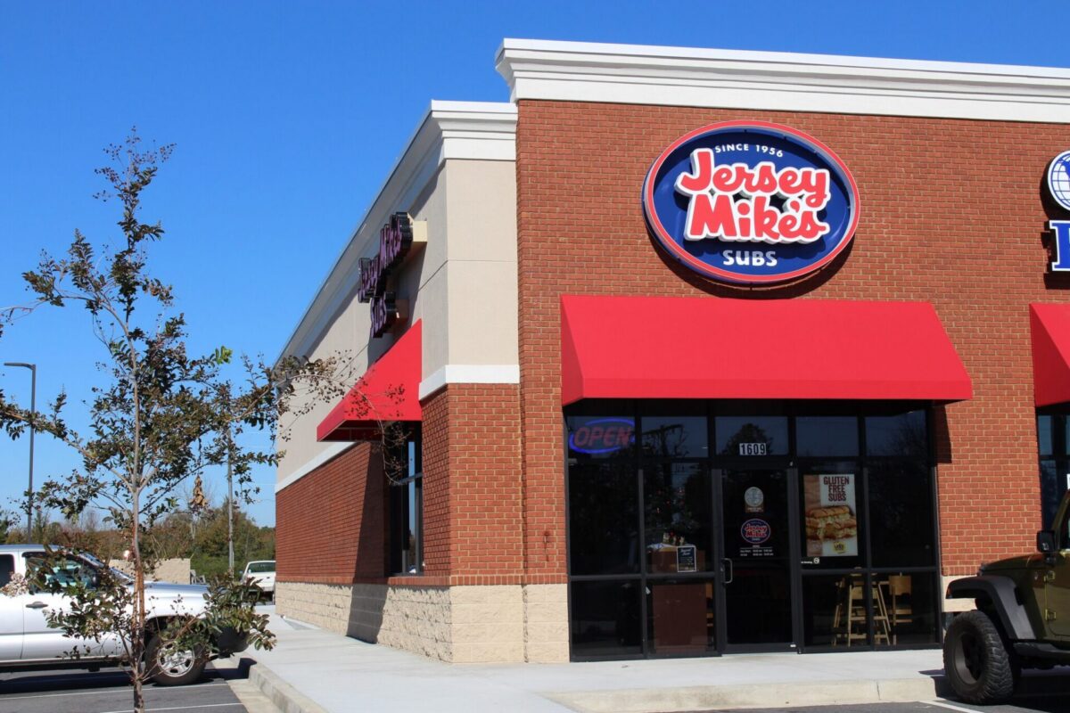 A Jersey Mike's Subs restaurant storefront with red awnings and the iconic logo sign