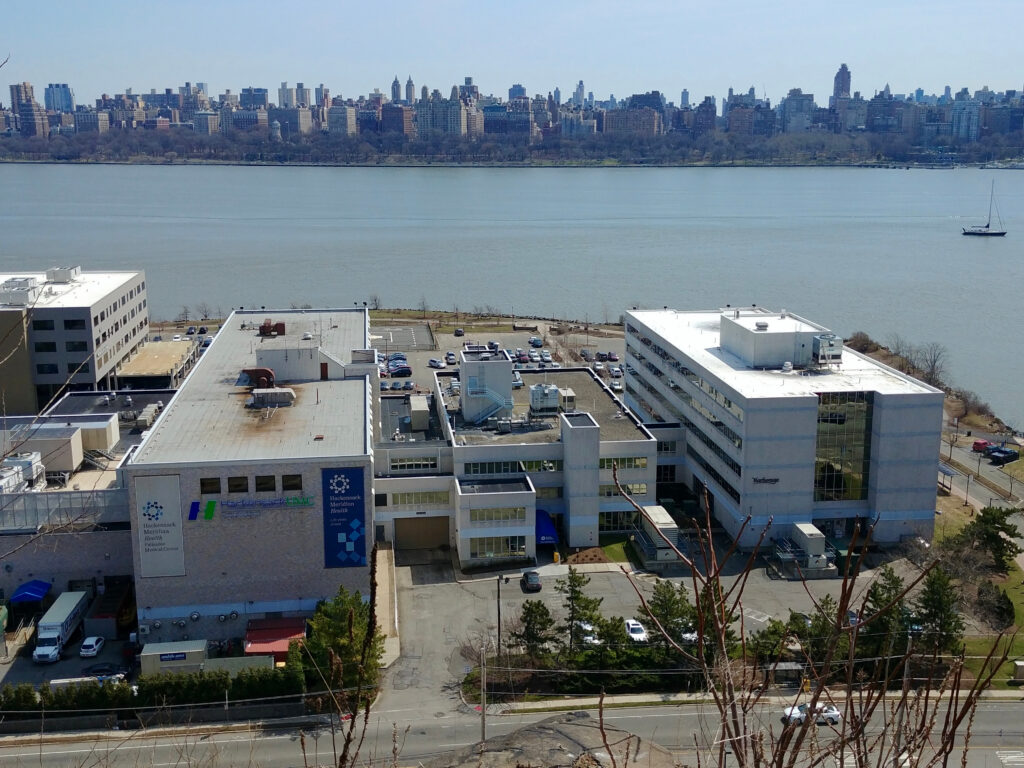 Palisades Medical Center in North Bergen, New Jersey with the Hudson River and Manhattan skyline in the background