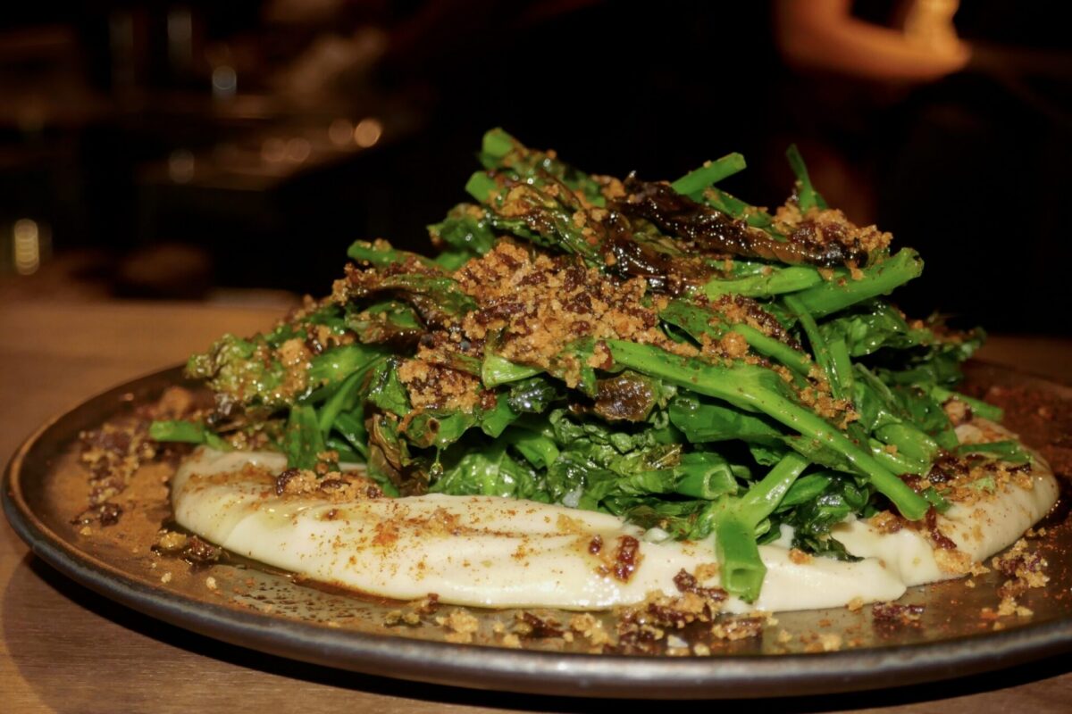 Pea shoots perched on a bed of white bean purée