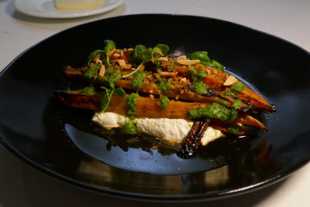 dish of roasted heirloom carrots with almonds, pesto, and ricotta