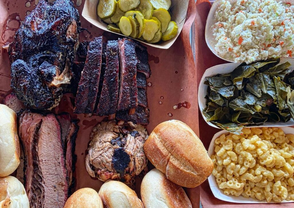 A barbecue spread featuring brisket, ribs, pulled pork, mac and cheese, and collard greens at a New Jersey barbecue restaurant