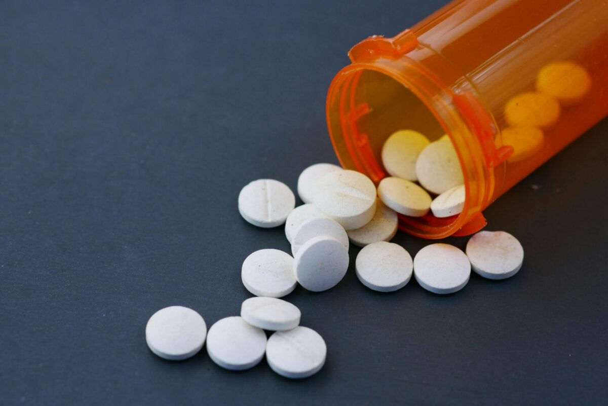 White prescription tablets spilling from an orange bottle representing a nationwide medication recall