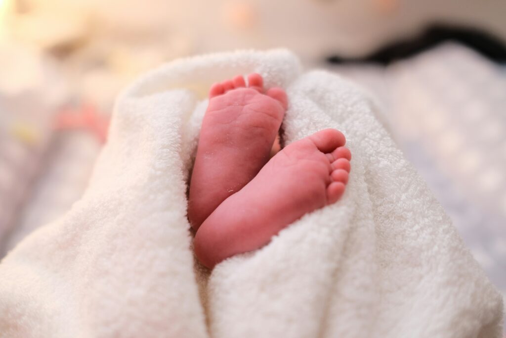 A newborn baby's feet wrapped in a white blanket