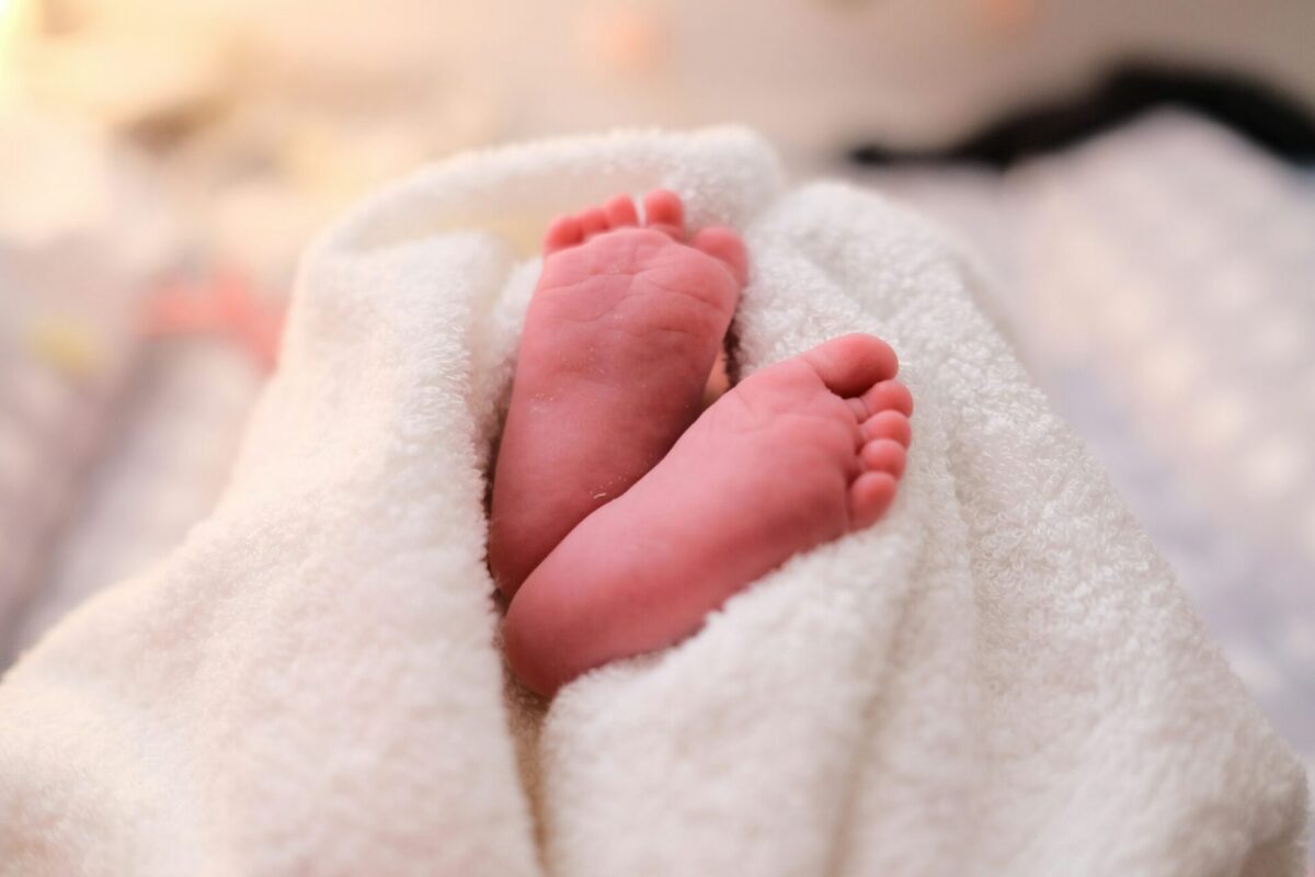 A newborn baby's feet wrapped in a white blanket