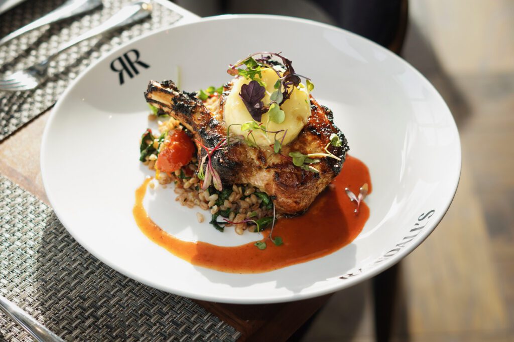 A char-grilled pork chop with farro and natural jus served at Randall's Restaurant in Cherry Hill, New Jersey