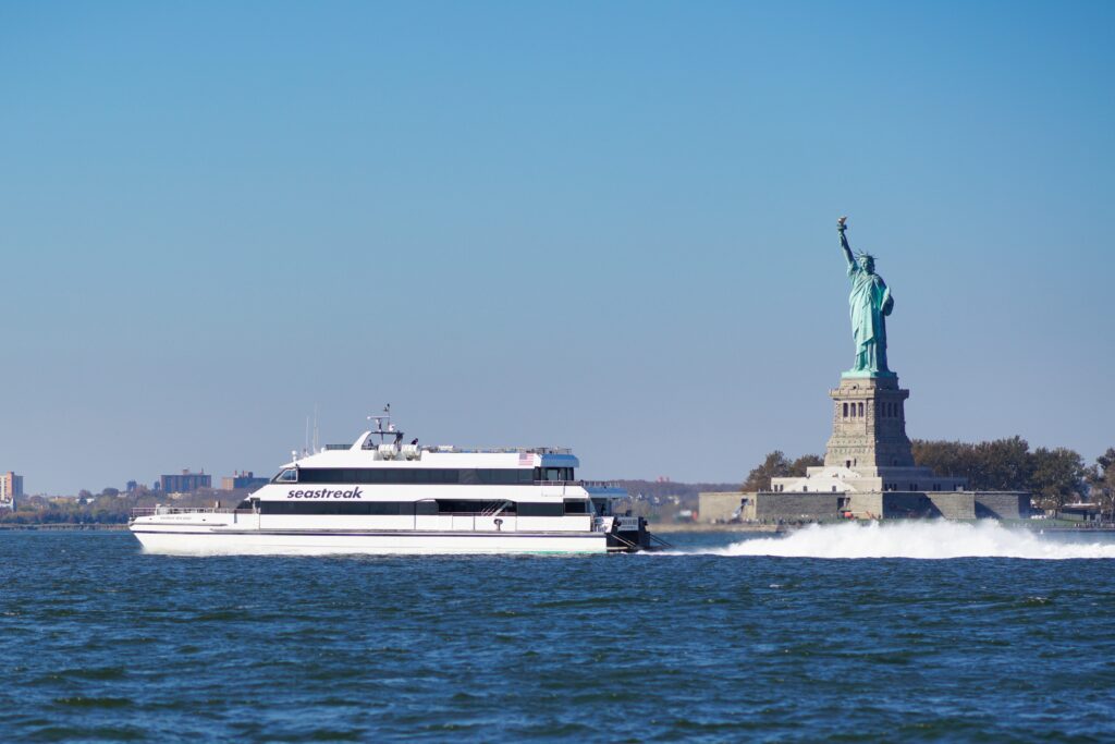 A Seastreak ferry passing the Statue of Liberty in New York Harbor