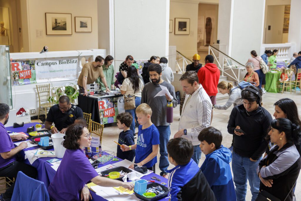 Families exploring hands-on science activities at STEAM Around the Square inside the Newark Museum of Art
