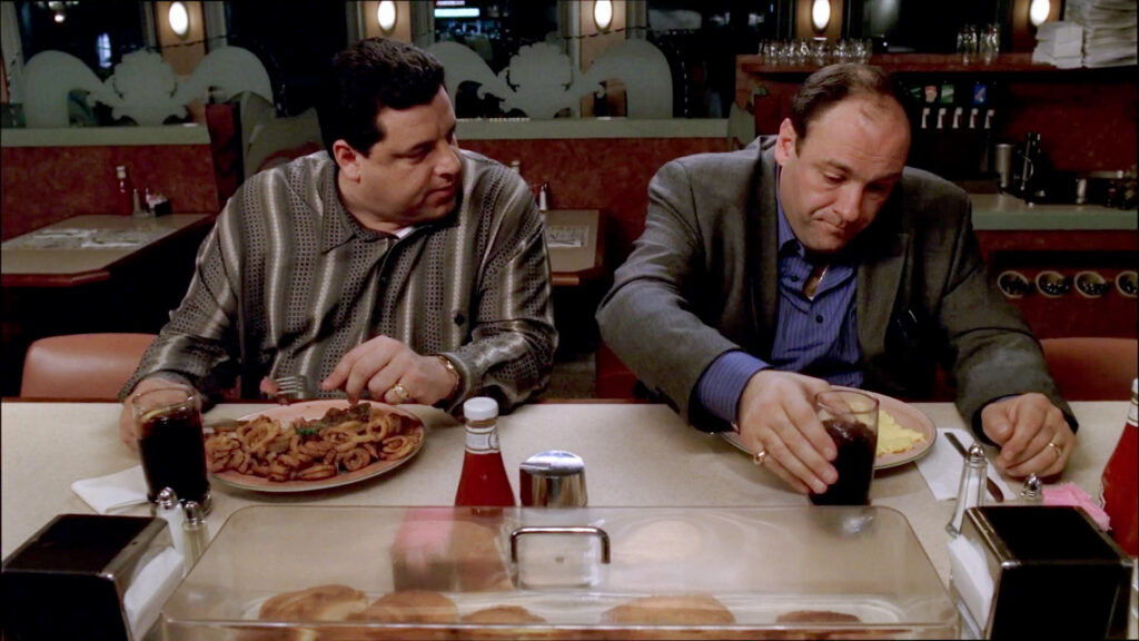 Tony Soprano and Bobby Baccalieri sit at a diner booth in a scene from The Sopranos.