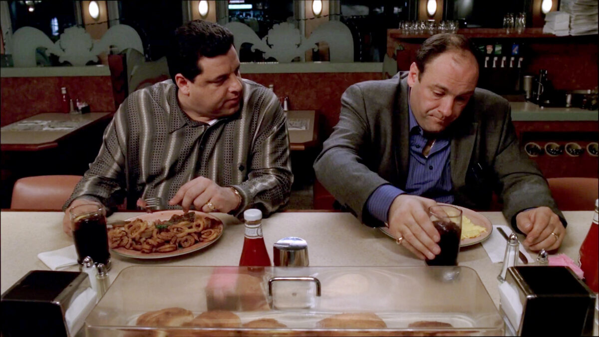 Tony Soprano and Bobby Baccalieri sit at a diner booth in a scene from The Sopranos.