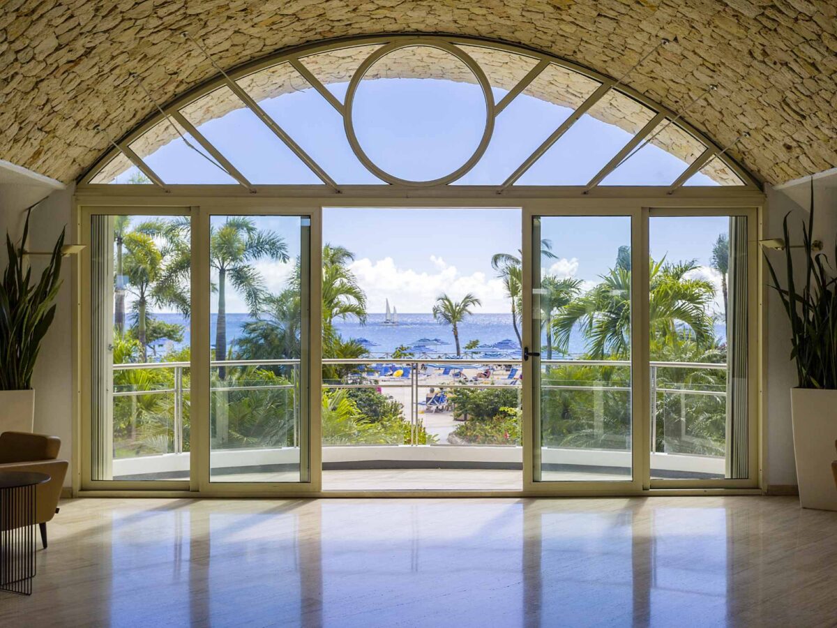 A suite balcony view of palm trees and the ocean at Royal Islander Club Resort La Plage on Maho Beach, St. Maarten