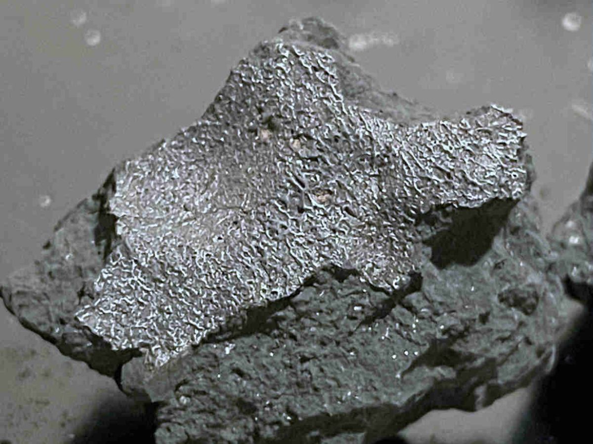 A fragment of the meteorite that crashed through a home's roof in Hillsborough, New Jersey, showing its gray, black, and silvery surface