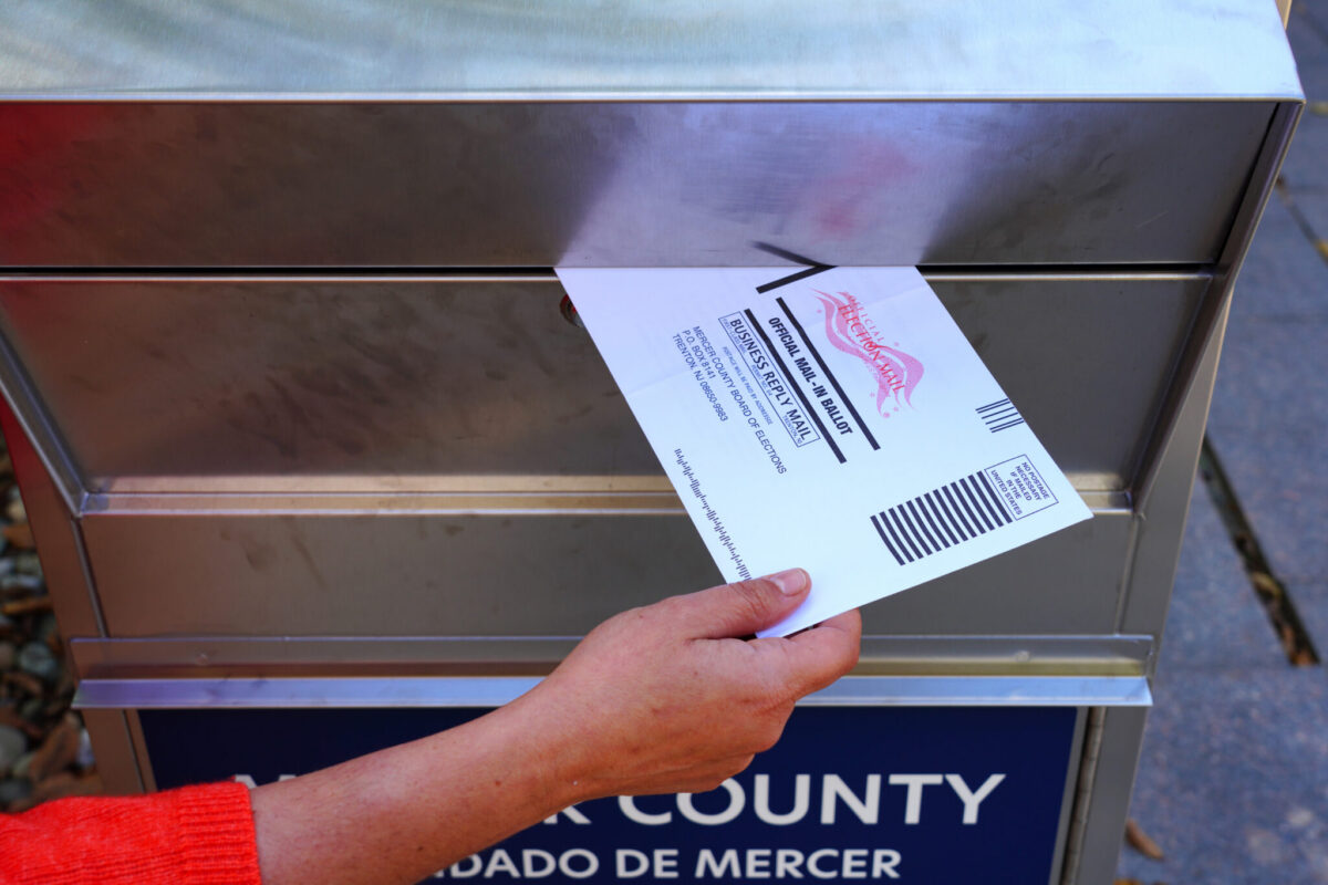 A voter drops off an official mail-in ballot at a Mercer County election box