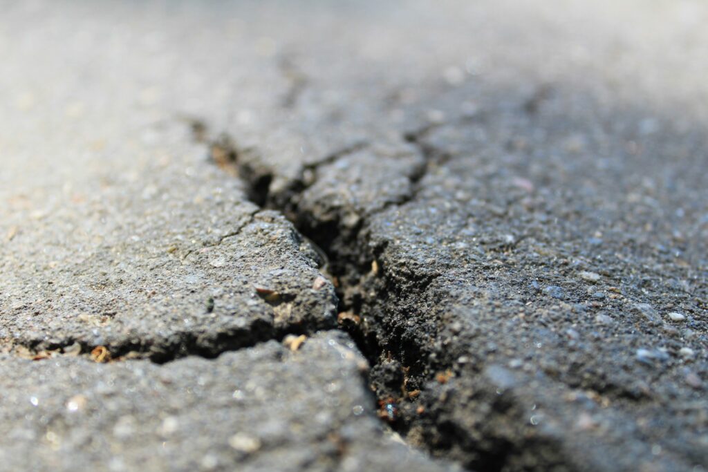 A cracked road surface, representing the fractured "immature" fault structure discovered beneath New Jersey