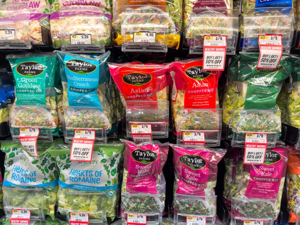 Taylor Farms salad kits on a grocery store shelf, the same supplier behind several private-label brands