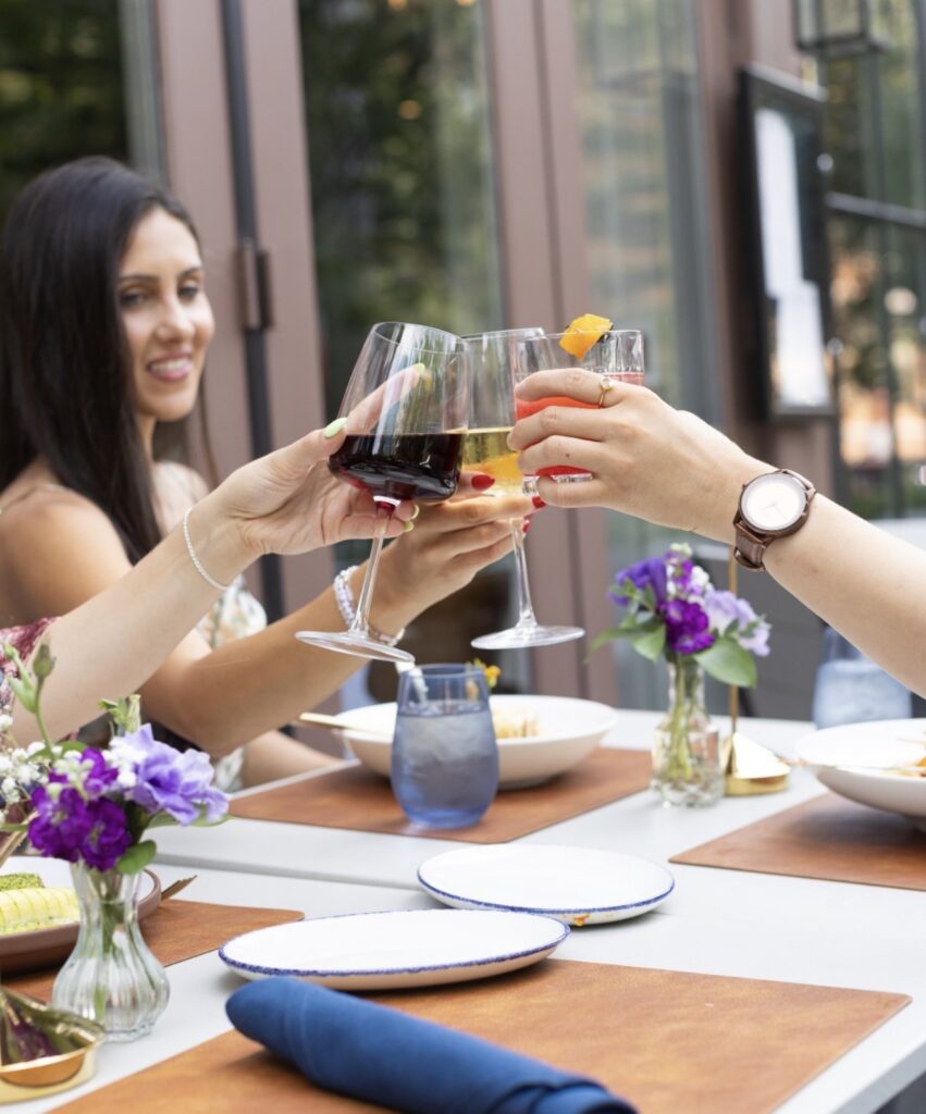 guests clank wine glasses at a patio table at 87 Sussex