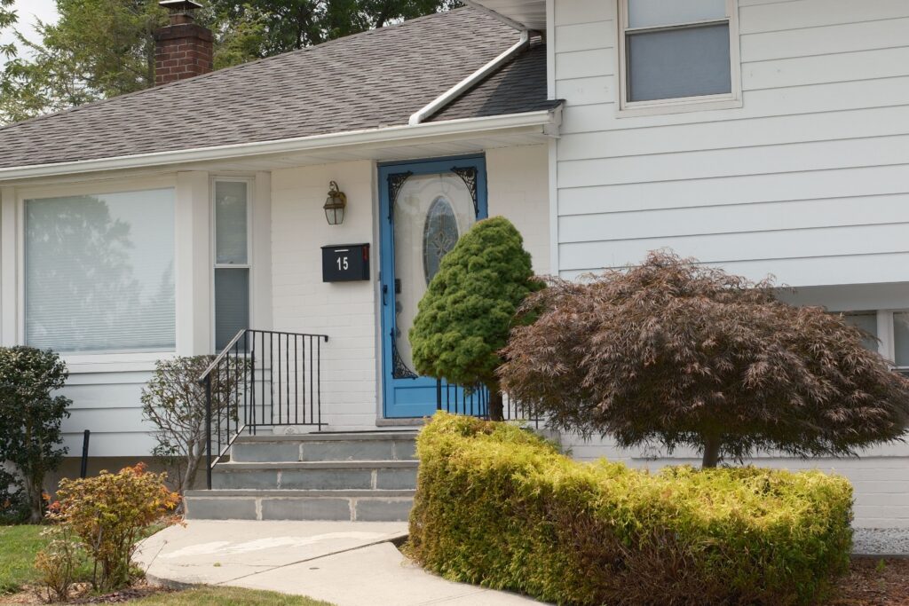 A white New Jersey house with a blue front door, representing homeowners and renters set to receive ANCHOR property tax relief payments