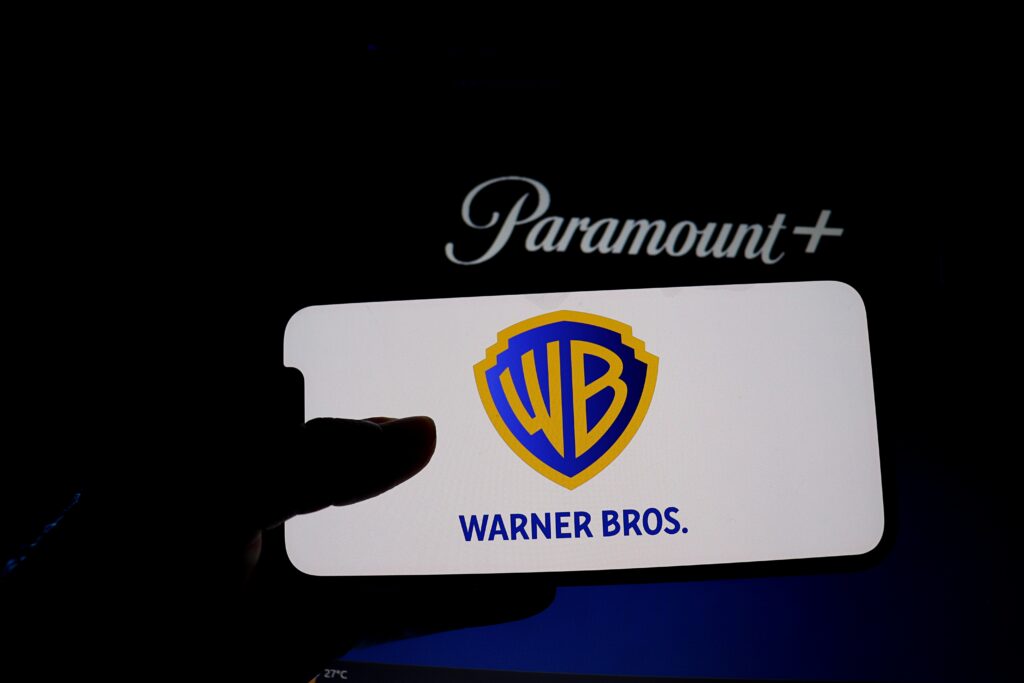 The Warner Bros. and Paramount+ logos, representing the merger dispute dividing New Jersey officials