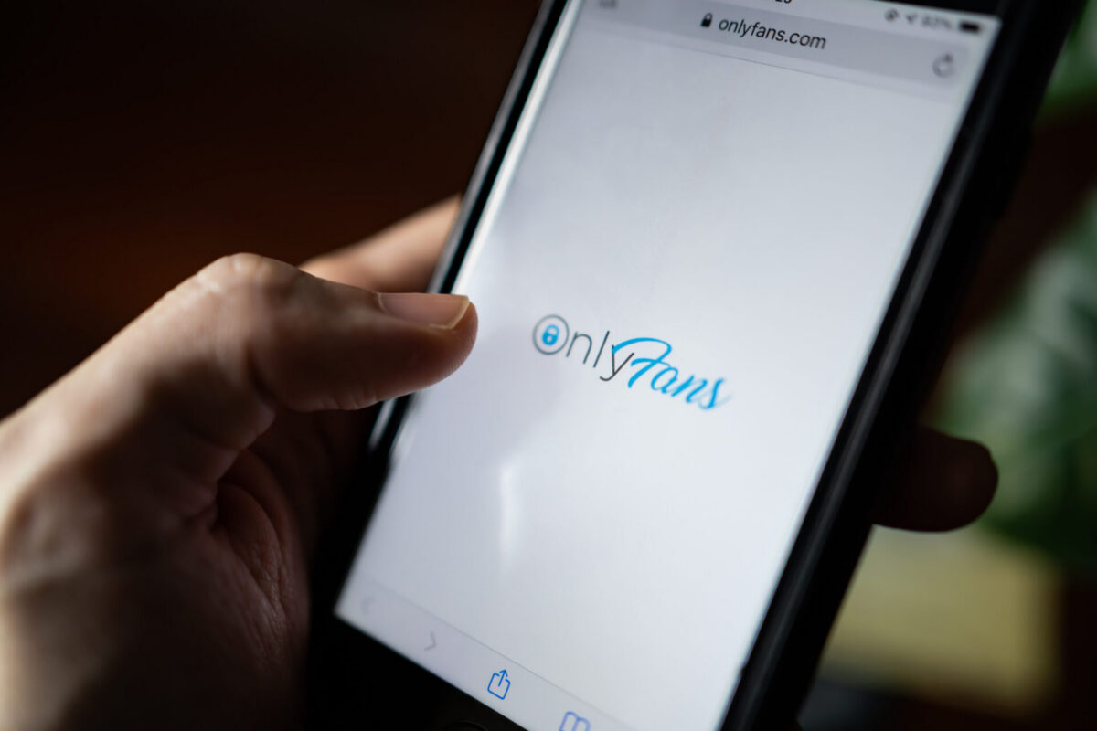 An iPhone with OnlyFans loading in a browser
