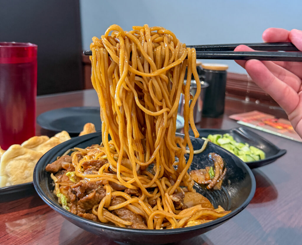 chopsticks lifting Sautéed Hand-Pulled Noodle With Beef from Shan Shan Noodles in Parsippany, NJ
