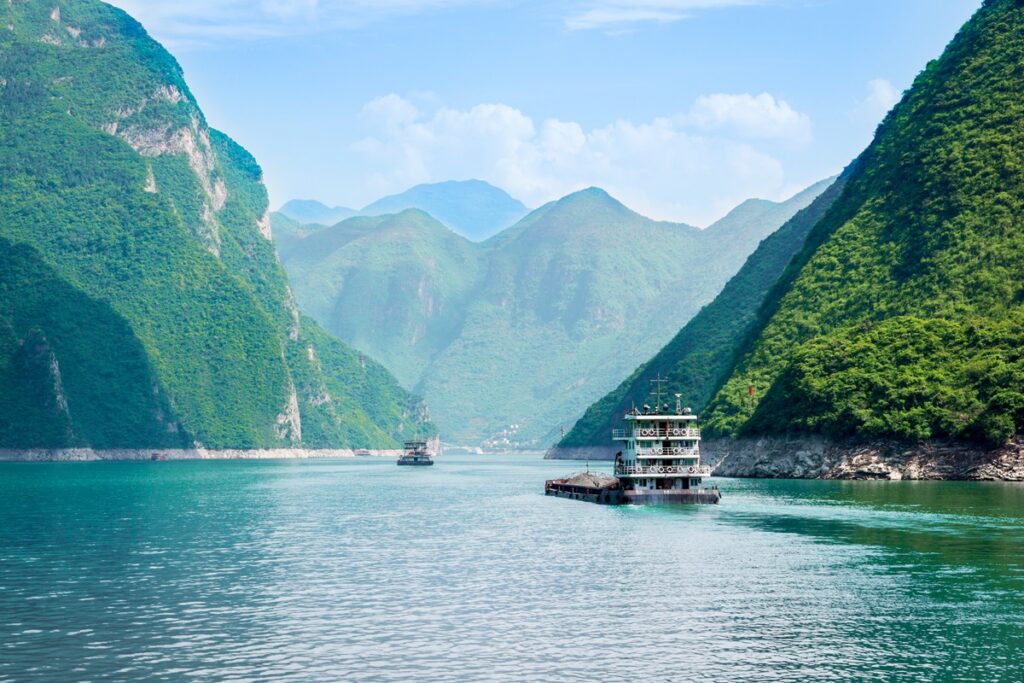 Turquoise waters of the Yangtze River cutting through the lush green mountains of the Three Gorges in central China