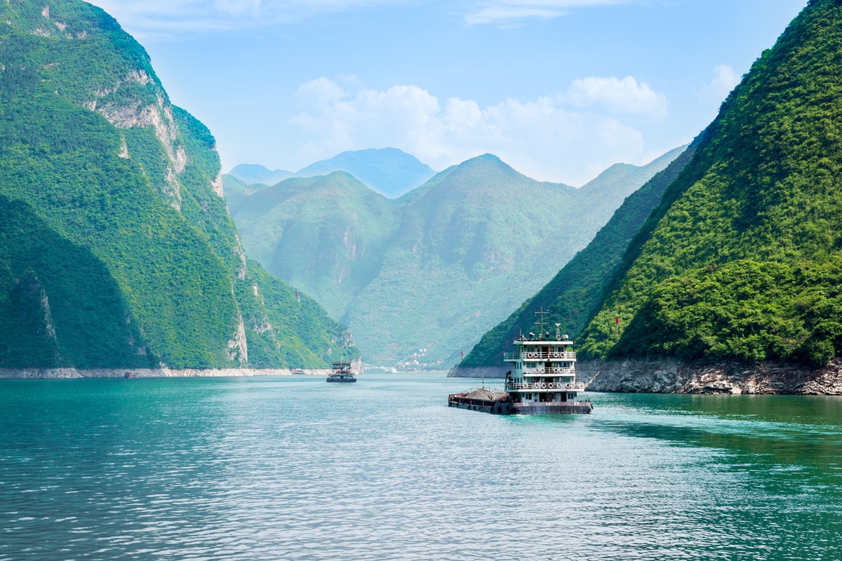 Turquoise waters of the Yangtze River cutting through the lush green mountains of the Three Gorges in central China
